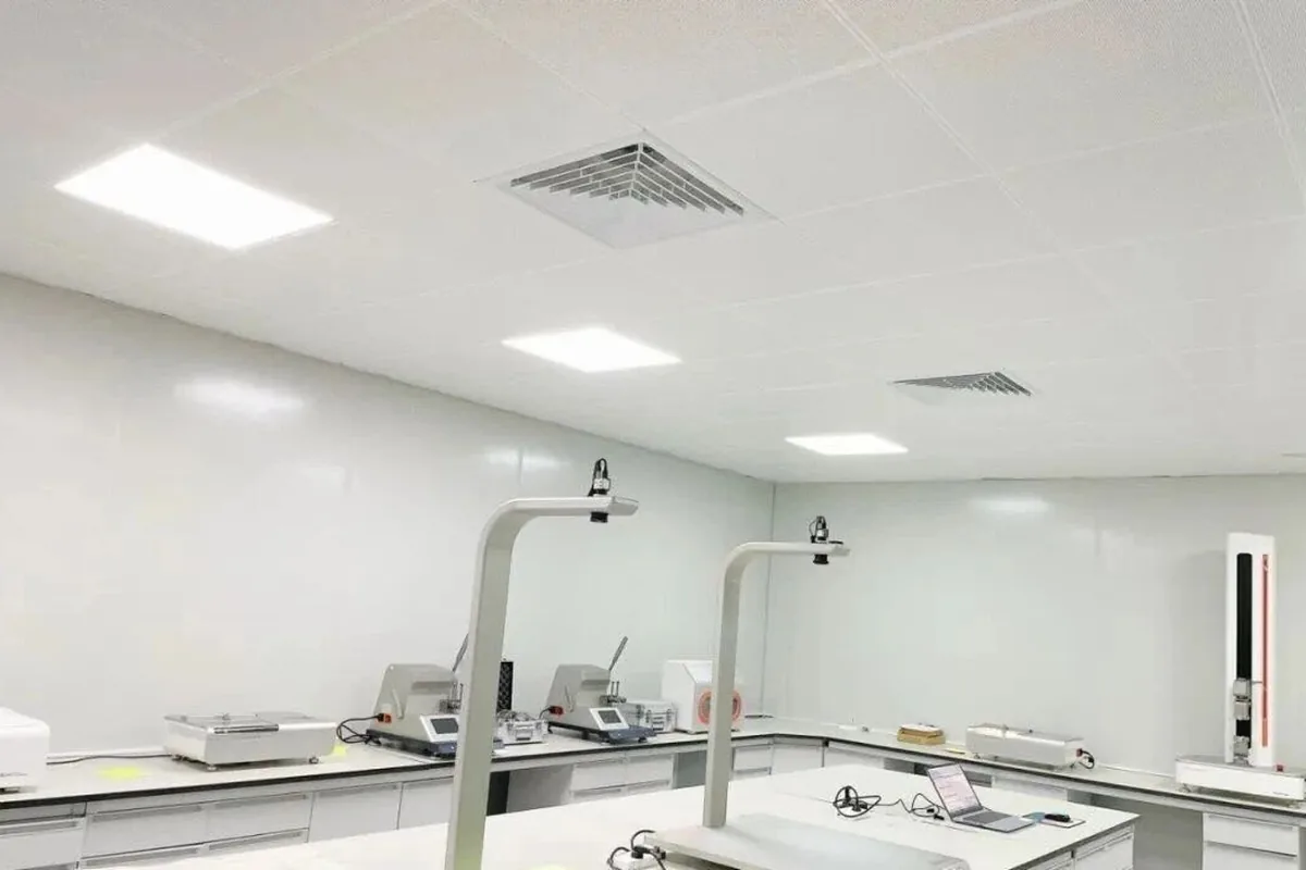 In-house testing laboratory at the woven vinyl production base in Zhejiang: benches with strength and moisture testing equipment and a bench-top camera rig