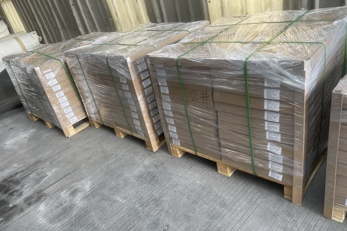 Pallets of boxed modular tiles wrapped and strapped, ready to load, at the woven vinyl production base in Zhejiang