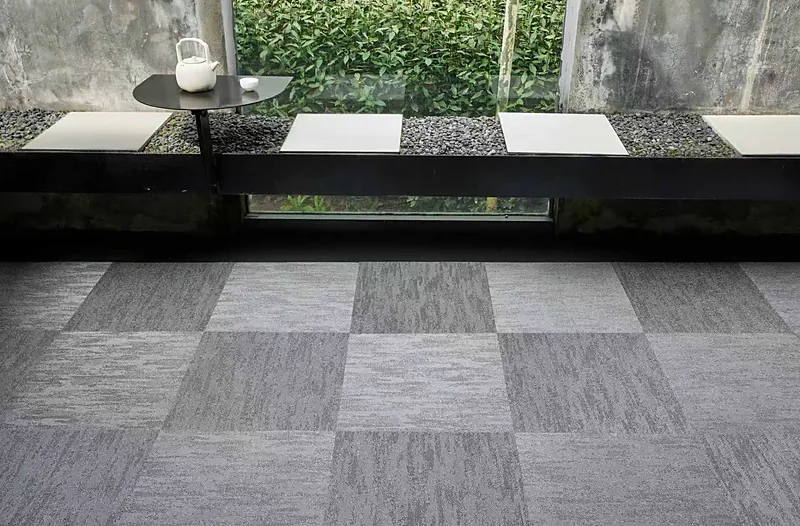 Acoustic modular carpet tiles in a woven vinyl grid pattern in an office